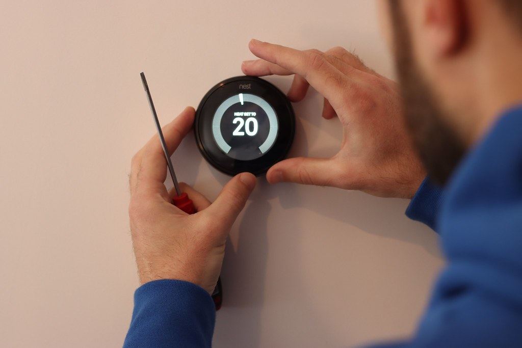 A heating engineer fitting a smart thermostat