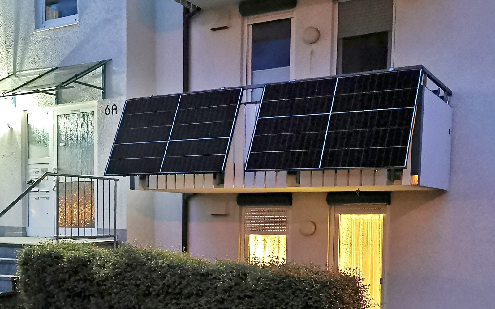 Two plug-in solar panel kits fixed to a ground-floor balcony
