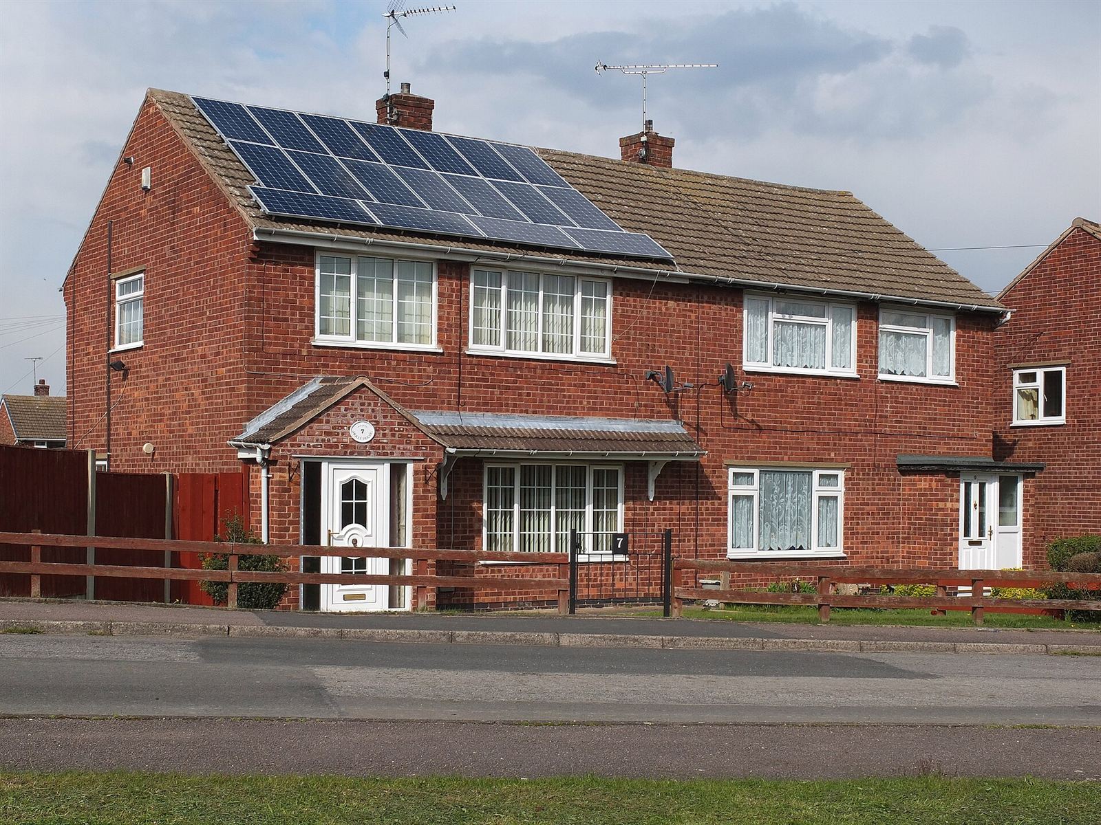 Solar panels on the roof of a red-brick semi-detached house