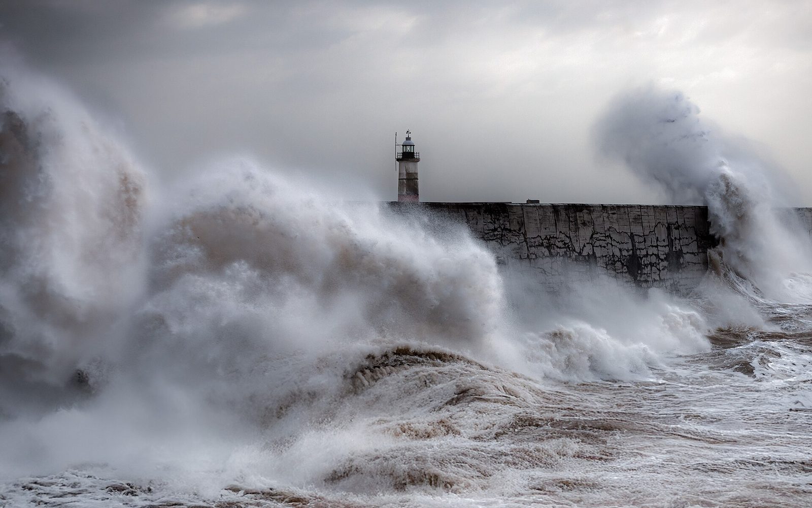 A storm surge breaking over Newhaven lighthouse, East Sussex